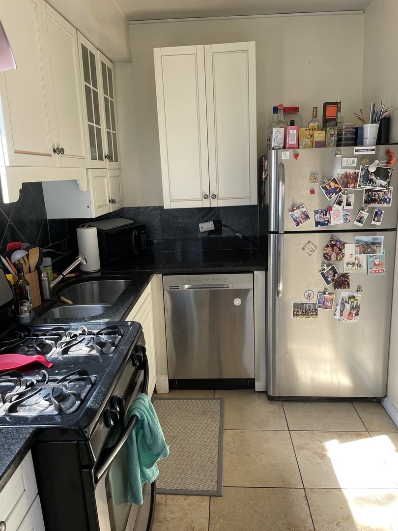 a kitchen with a refrigerator and a stove top oven