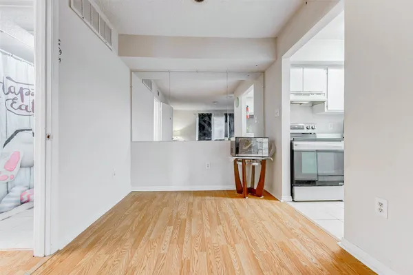 a room with a wooden floor and a kitchen