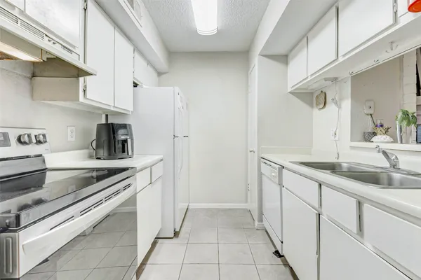 a kitchen with stainless steel appliances granite countertop a sink and dishwasher a refrigerator