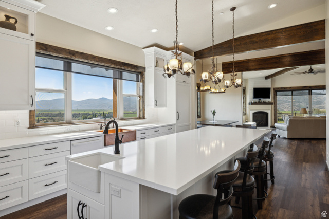 6117 North Rocky Ridge Road Peoa, UT 84061 - Photo 42 of 82 Spacious kitchen featuring an expansive island with seating, white shaker cabinetry, an apron-front sink, and a copper basin
