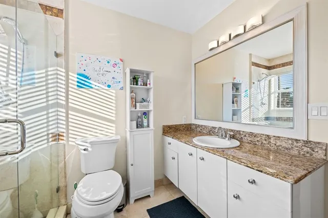 a front view of a house with garden and trees