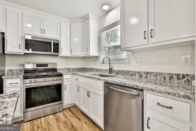 a kitchen with stainless steel appliances granite countertop a stove top oven microwave and cabinets