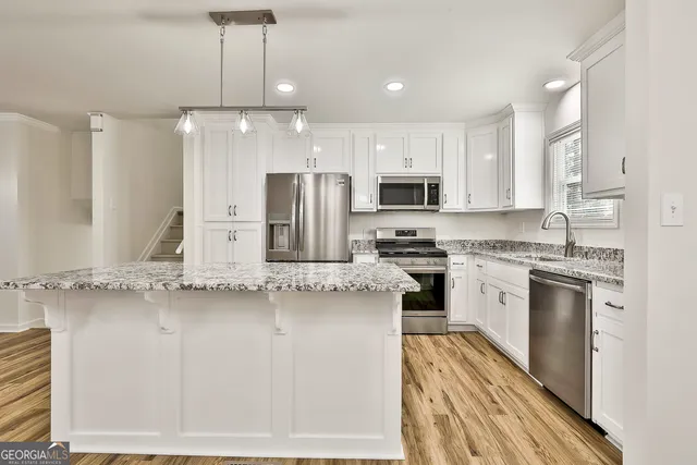 a kitchen with stainless steel appliances granite countertop a stove a sink and a refrigerator