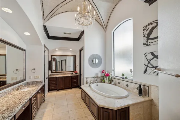a bathroom with a granite countertop double vanity sink and a mirror