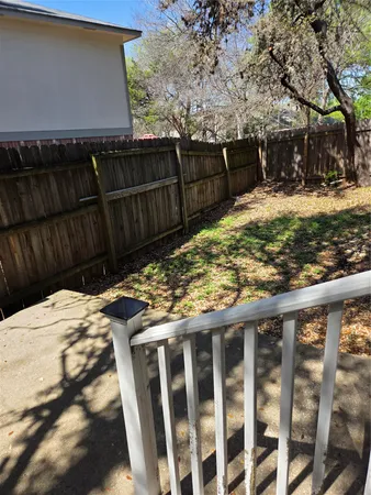 a view of a backyard with wooden fence