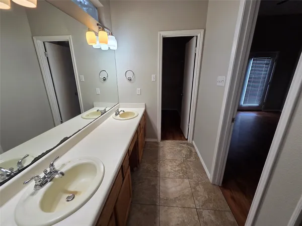 a en suite bathroom with a double vanity sink and a mirror