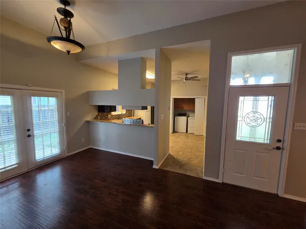 a view of a room with wooden floor and a window