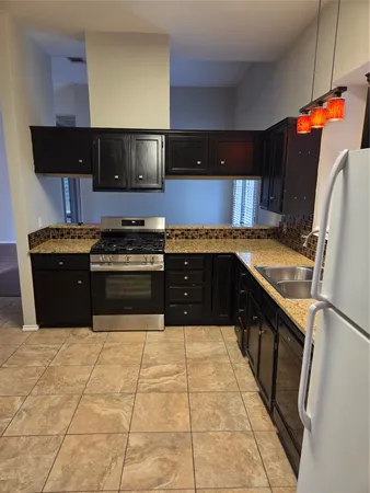 a kitchen with stainless steel appliances granite countertop a stove a sink and a microwave
