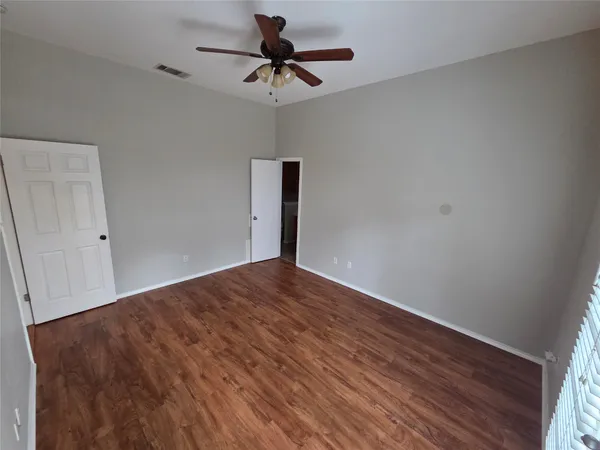 a view of empty room with wooden floor