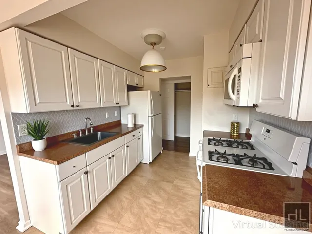 a kitchen with stainless steel appliances a sink stove and cabinets
