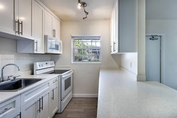 a kitchen with stainless steel appliances a sink a stove a refrigerator and cabinets