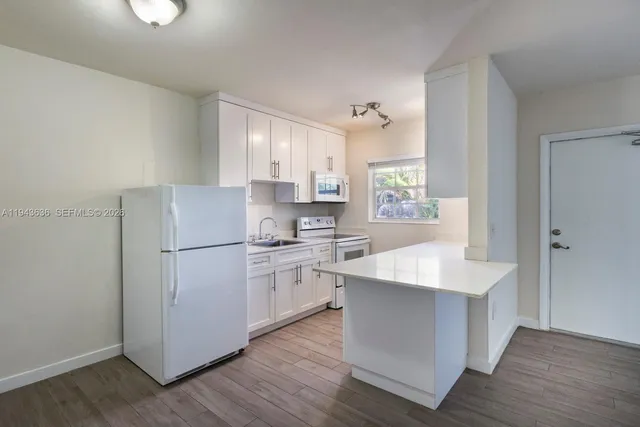 a kitchen with white cabinets and white appliances