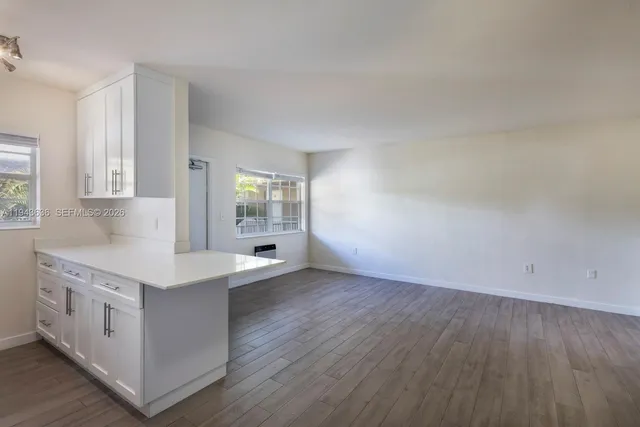a kitchen with a sink cabinets and wooden floor