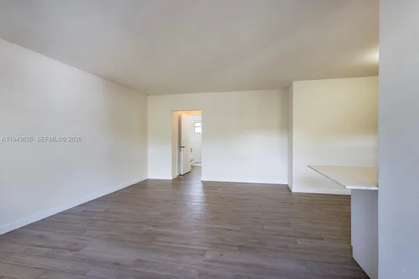 a view of an empty room and wooden floor