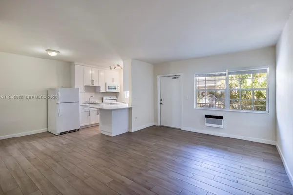 a kitchen with stainless steel appliances wooden floor and a window