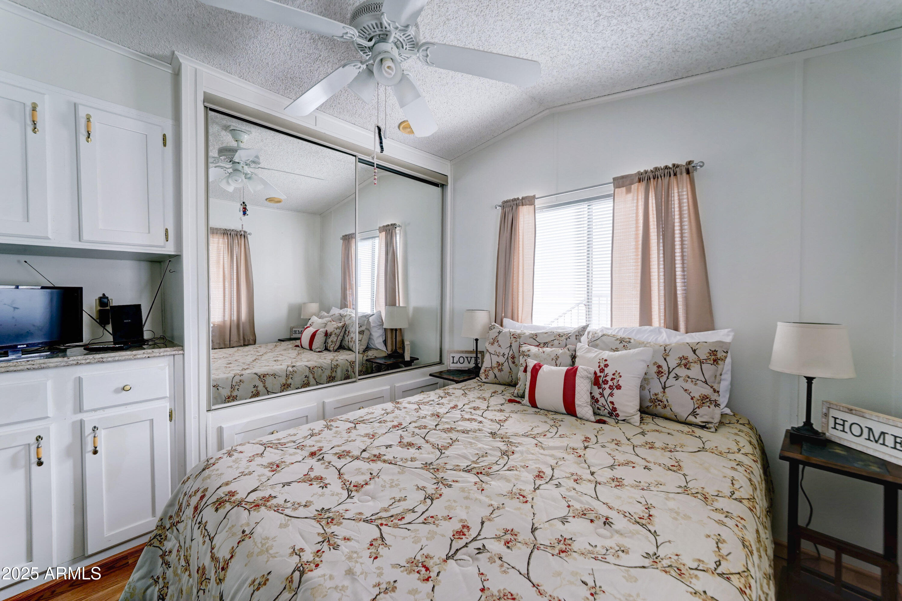 111 South Greenfield Road, Unit 481 Mesa, AZ 85206 - Photo 12 of 22 a spacious bedroom with a large bed and a chandelier