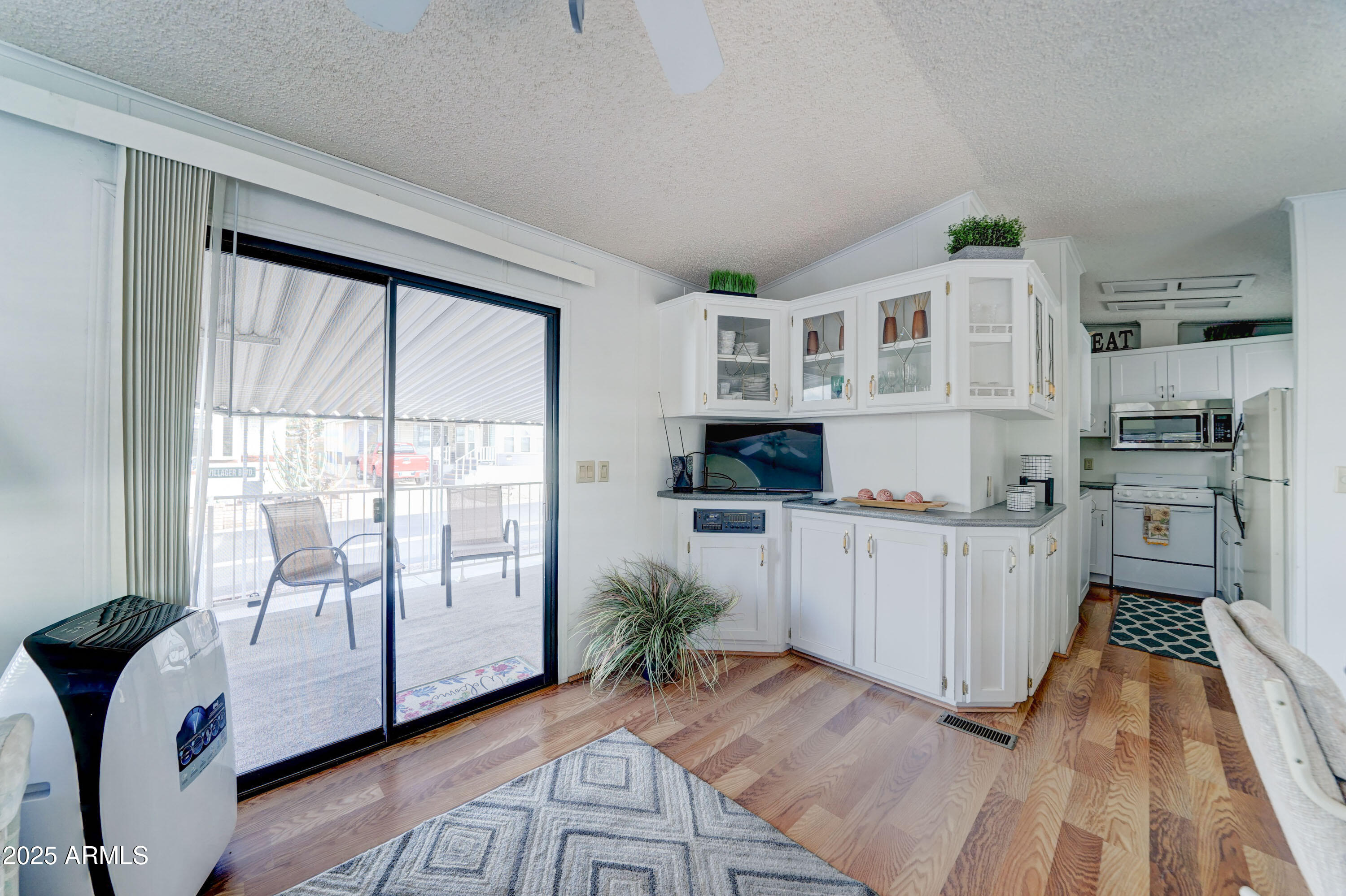 111 South Greenfield Road, Unit 481 Mesa, AZ 85206 - Photo 7 of 22 a kitchen with white cabinets and wooden floor