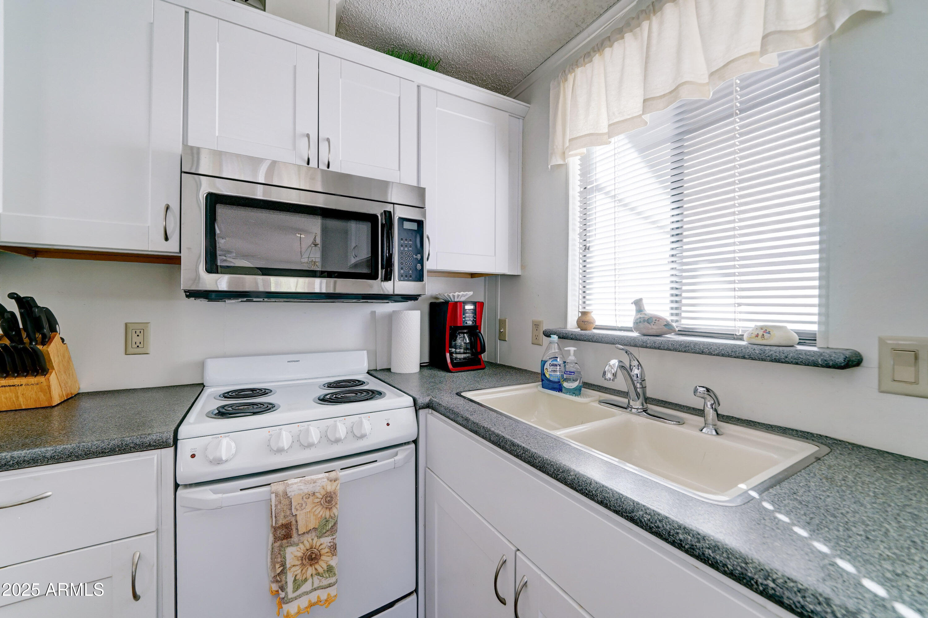 111 South Greenfield Road, Unit 481 Mesa, AZ 85206 - Photo 9 of 22 a kitchen with granite countertop a sink a window and cabinets