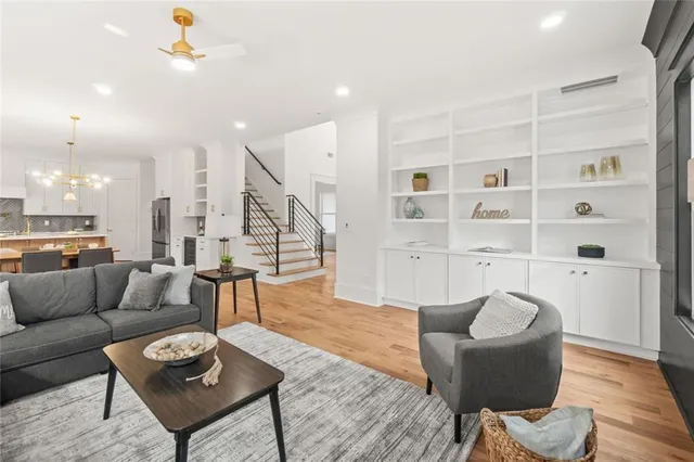 a dining hall with stainless steel appliances kitchen island granite countertop a dining table chairs and view living room