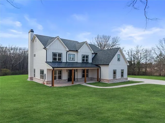 a front view of a house with a garden and trees