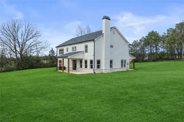 a front view of house with backyard and green space