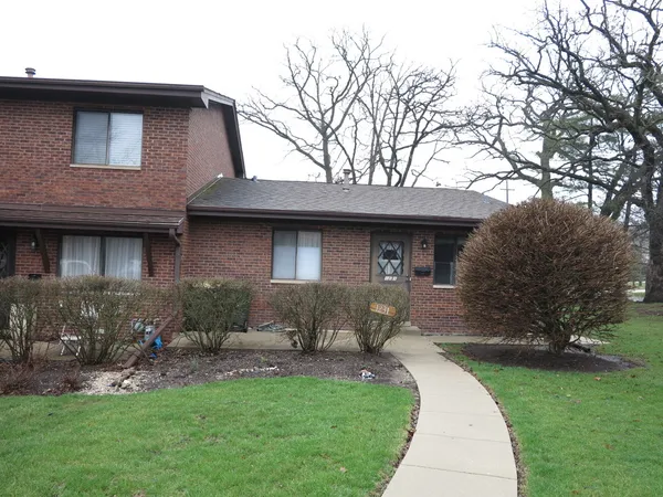 a front view of a house with a garden and yard