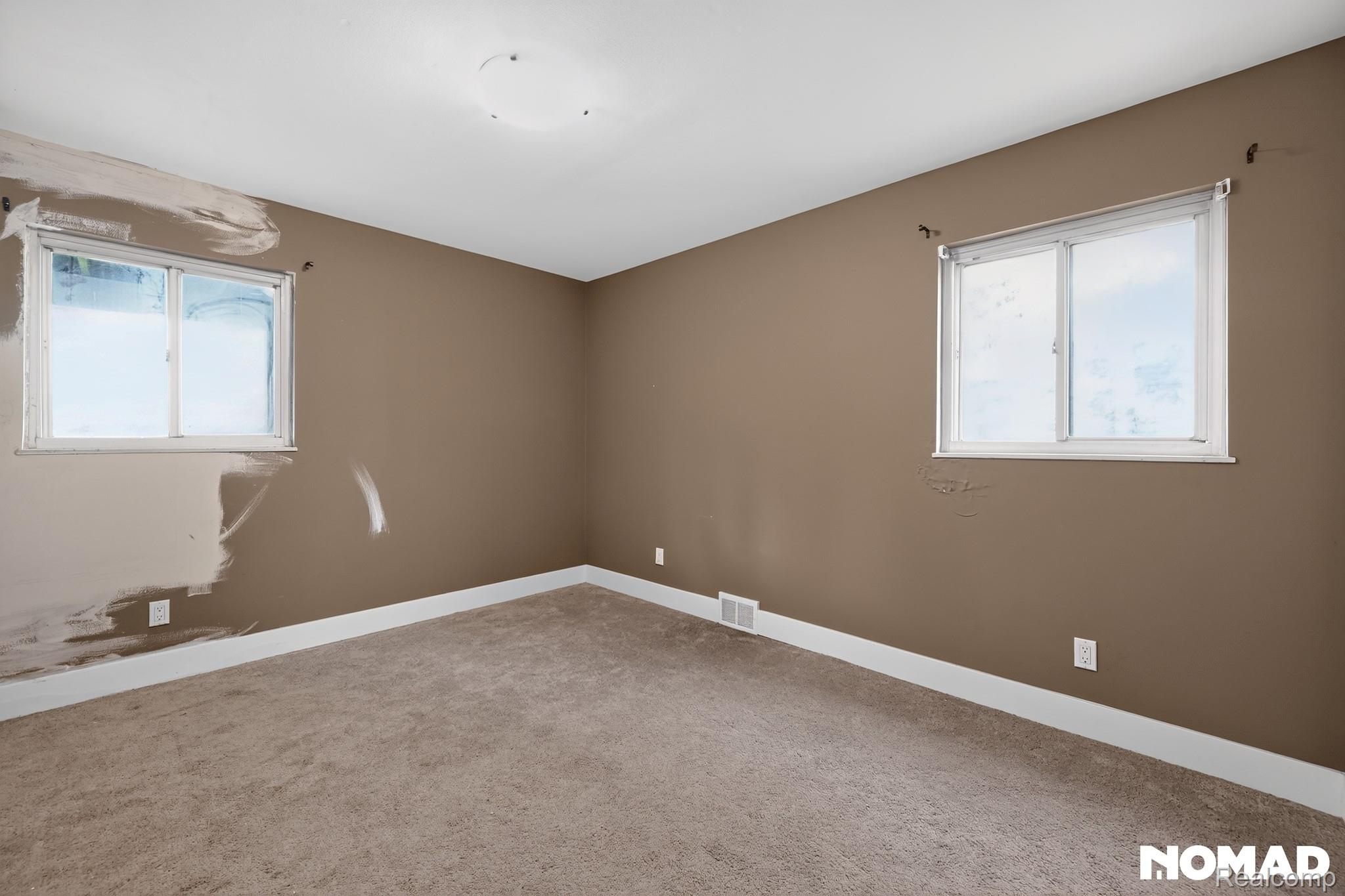 8315 Hilton Road Brighton, MI 48114 - Photo 13 of 26 Carpeted interior space with two windows and a ceiling-mounted light fixture