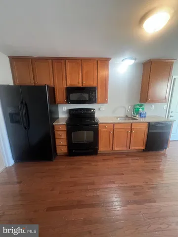 a kitchen with stainless steel appliances granite countertop a refrigerator a stove and a sink