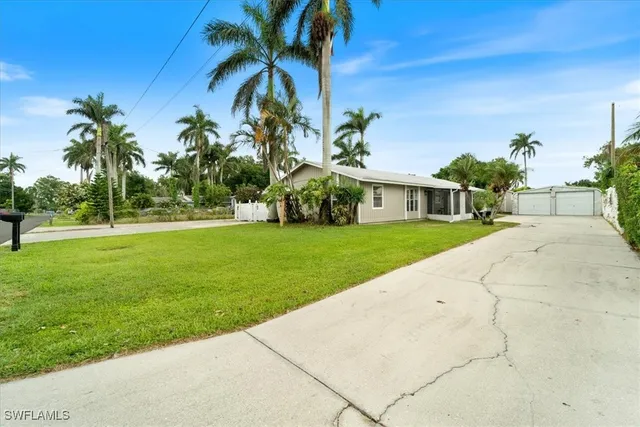 a front view of a house with a yard and potted plants