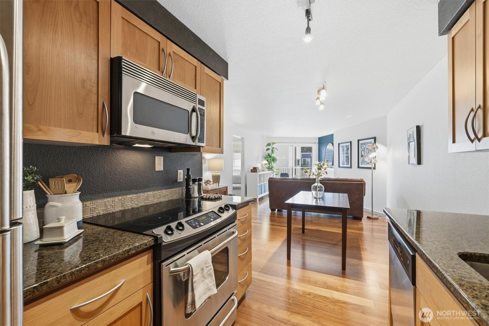 3045 20th Avenue West, Unit 303 Seattle, WA 98199 - Photo 13 of 28 a kitchen with stainless steel appliances granite countertop a stove a sink and a microwave
