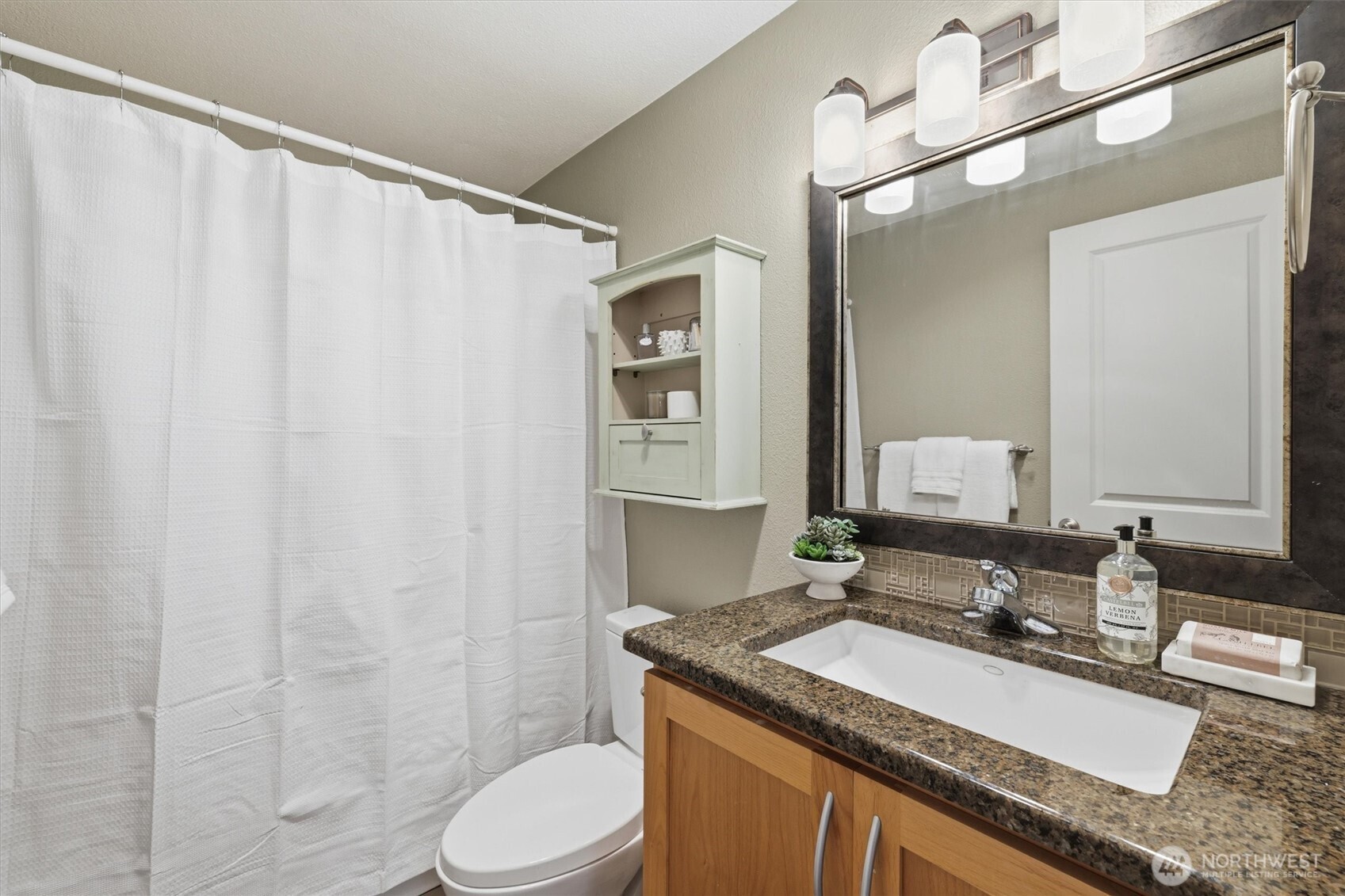 3045 20th Avenue West, Unit 303 Seattle, WA 98199 - Photo 16 of 28 a bathroom with a granite countertop sink and a mirror