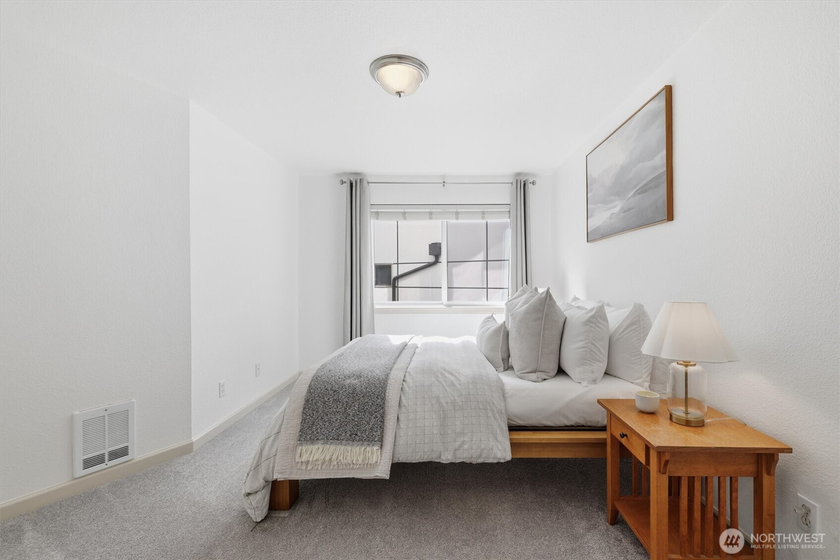 3045 20th Avenue West, Unit 303 Seattle, WA 98199 - Photo 18 of 28 a bedroom with a bed and wooden floor