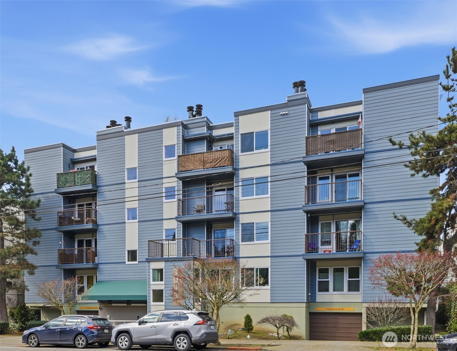 3045 20th Avenue West, Unit 303 Seattle, WA 98199 - Photo 3 of 28 a front view of a residential apartment building with a yard
