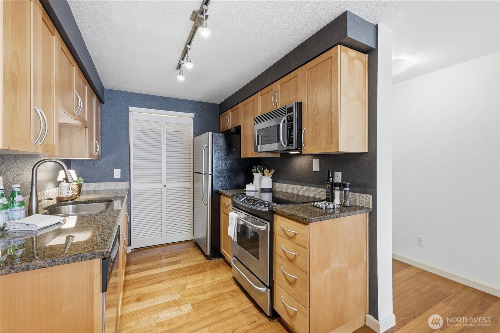 3045 20th Avenue West, Unit 303 Seattle, WA 98199 - Photo 10 of 28 a kitchen with stainless steel appliances granite countertop a stove and a sink