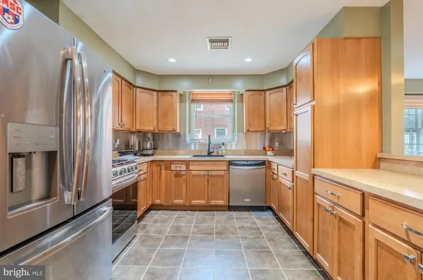 a kitchen with stainless steel appliances granite countertop a refrigerator and a sink