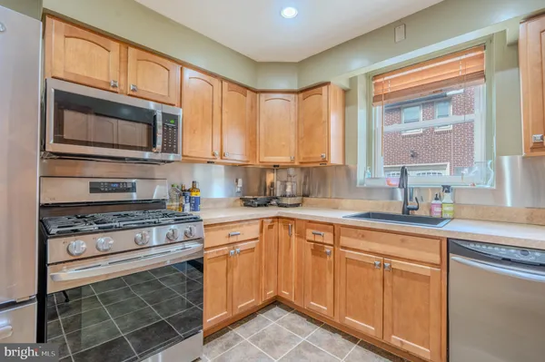 a kitchen with cabinets appliances a sink and a window