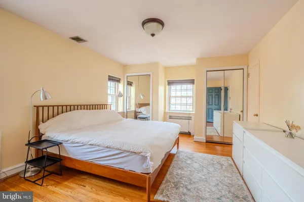a bed sitting in a spacious bedroom next to a window