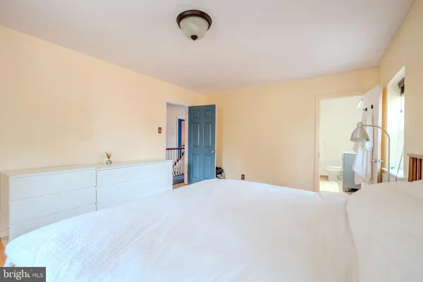 a bedroom with a bed and a large mirror