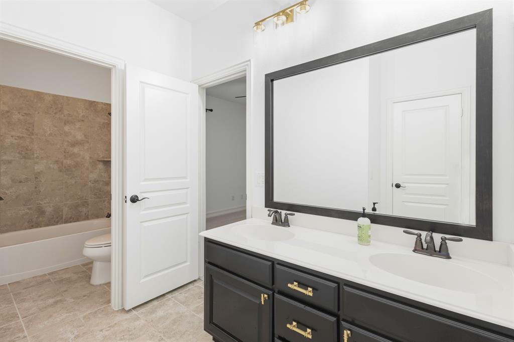 1995 Verde Court Allen, TX 75013 - Photo 9 of 30 Double vanity with dark cabinetry, white countertops, and dual undermount sinks