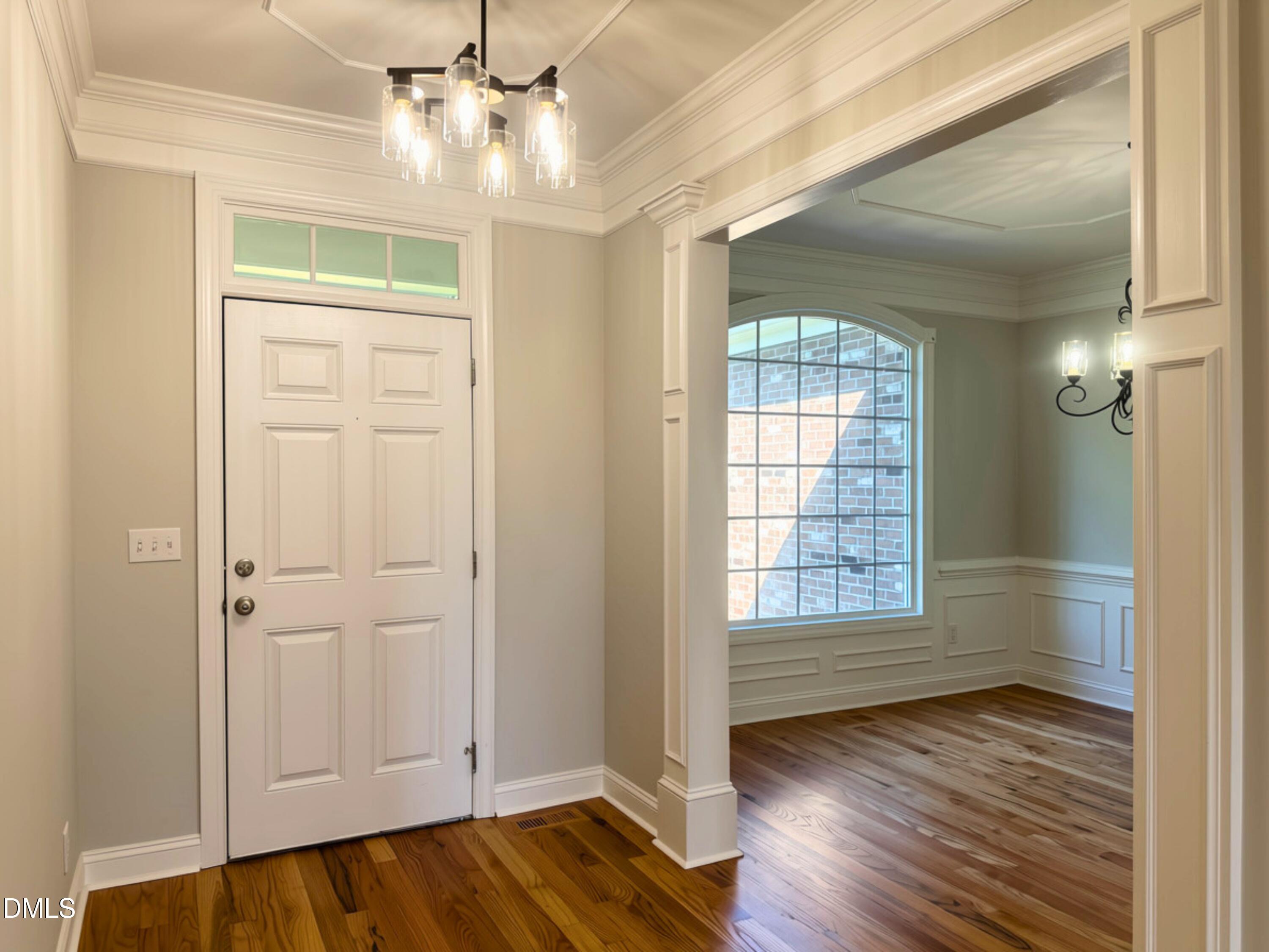 3100 Donlin Drive Wake Forest, NC 27587 - Photo 4 of 67 Hardwood flooring throughout, featuring a paneled entry door with transom window, and a decorative chandelier