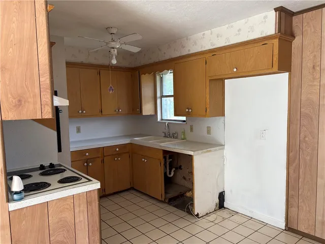 a kitchen with a stove sink and cabinets