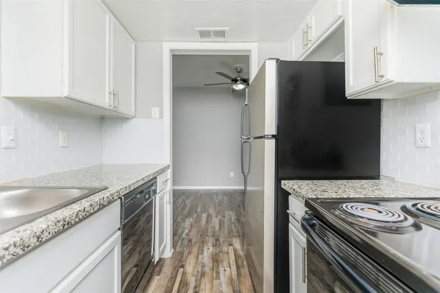 a kitchen with granite countertop a sink stove and refrigerator