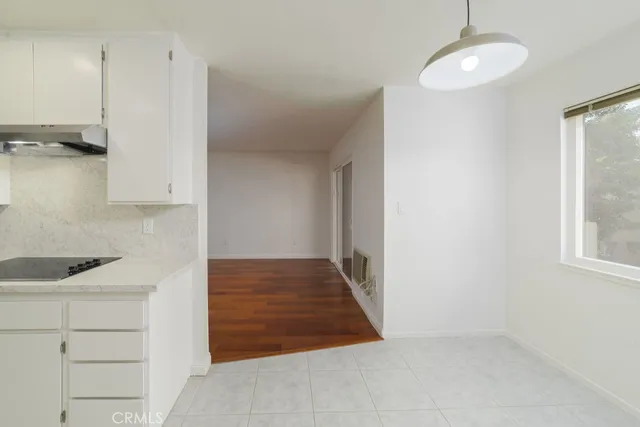 a kitchen with white cabinets and window