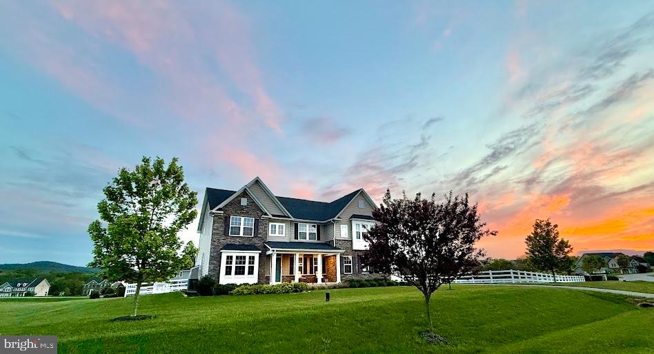 a view of a big house with a big yard and large trees