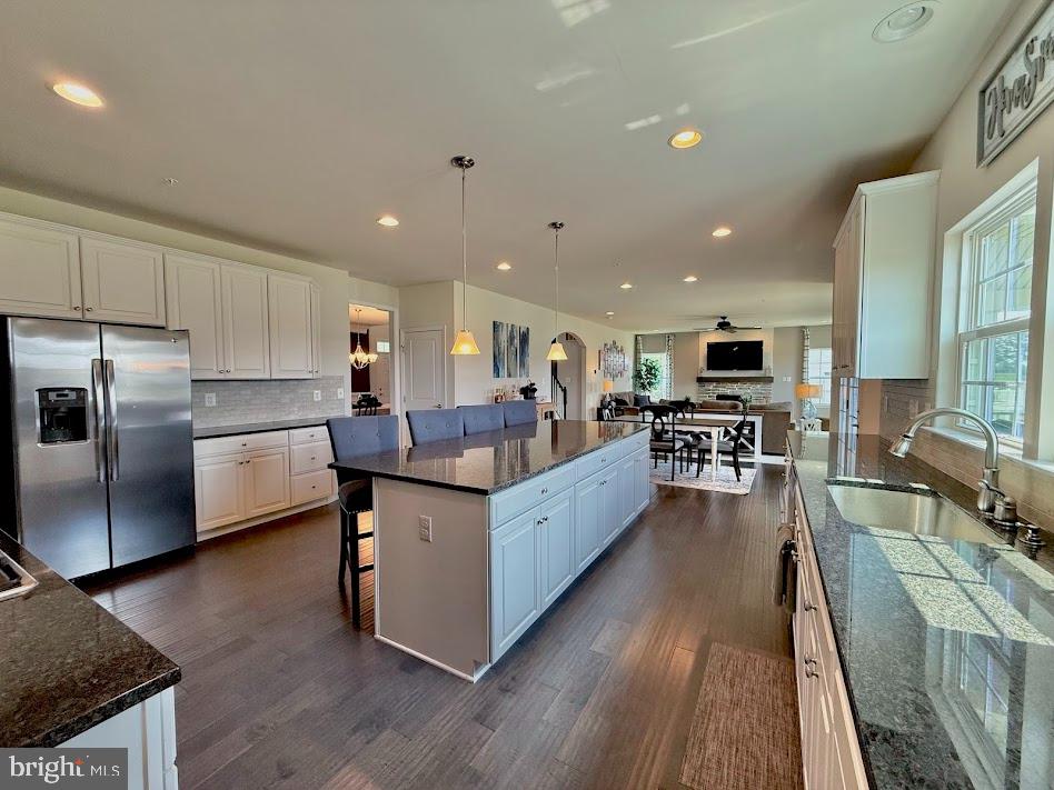 3012 Wasatch View Drive Frederick, MD 21704 - Photo 17 of 54 a large white kitchen with stainless steel appliances granite countertop lots of counter top space a refrigerator a stove a dining table and chairs with wooden floor