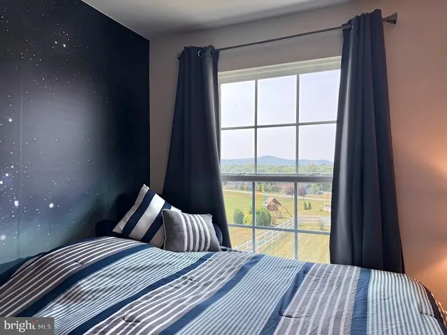 a bedroom with a bed chandelier and a window