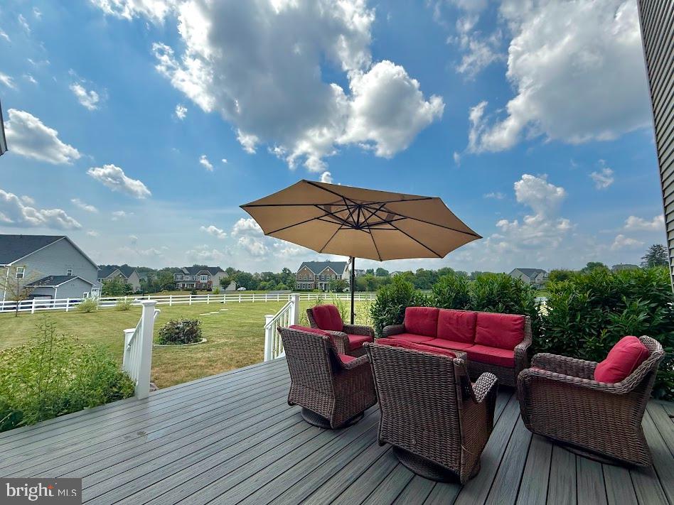3012 Wasatch View Drive Frederick, MD 21704 - Photo 43 of 54 a view of a deck with couches chairs under an umbrella with wooden floor