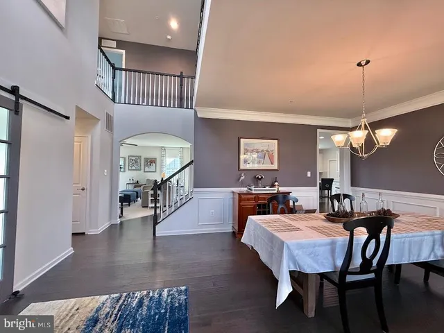 a dining room with furniture a chandelier and wooden floor