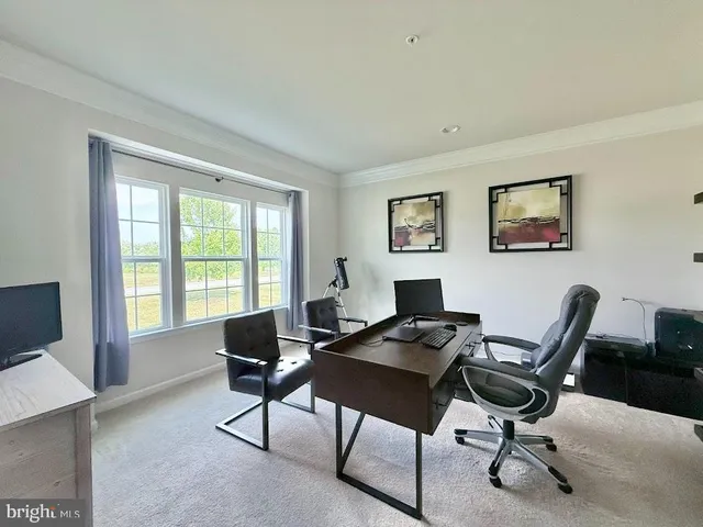 a view of a livingroom with workspace and a window