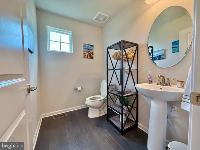 a bathroom with a toilet sink and mirror